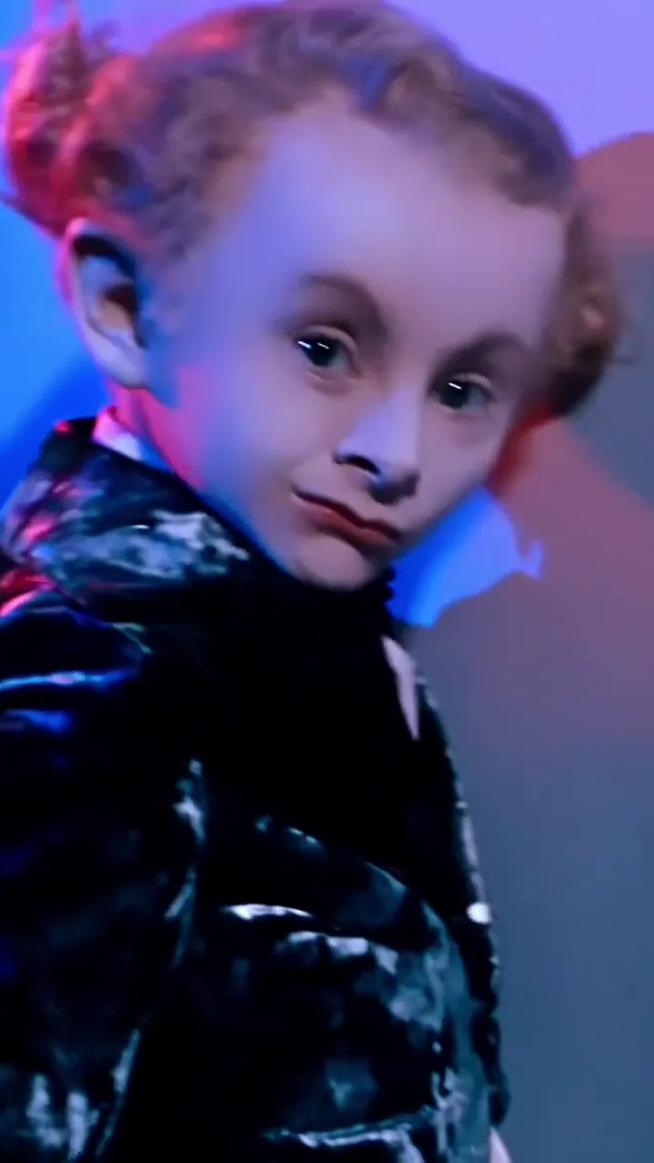 Rumpelstiltskin AI video trend: the imp in a black velvet jacket looks back over the shoulder with a sly grin