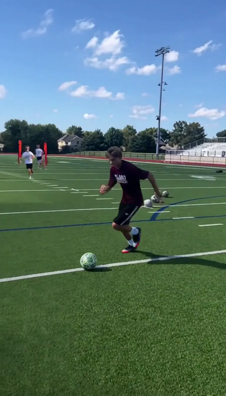 Ozil goal AI video trend: a teenager in a maroon shirt runs onto the ball on a school pitch