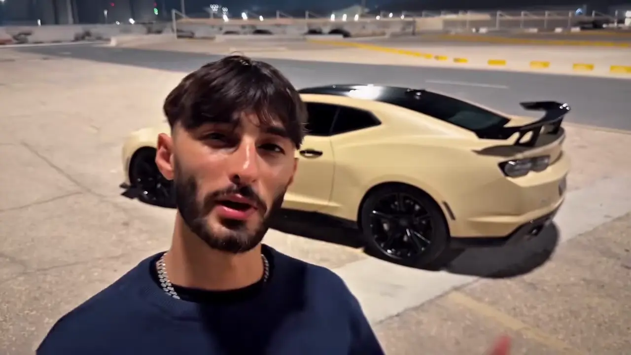 Unforgettable car AI video trend: a man with a cream coupe parked behind him on a sandy lot